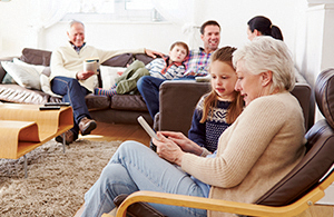 family with a grandmother and granddaughter looking at an ipad